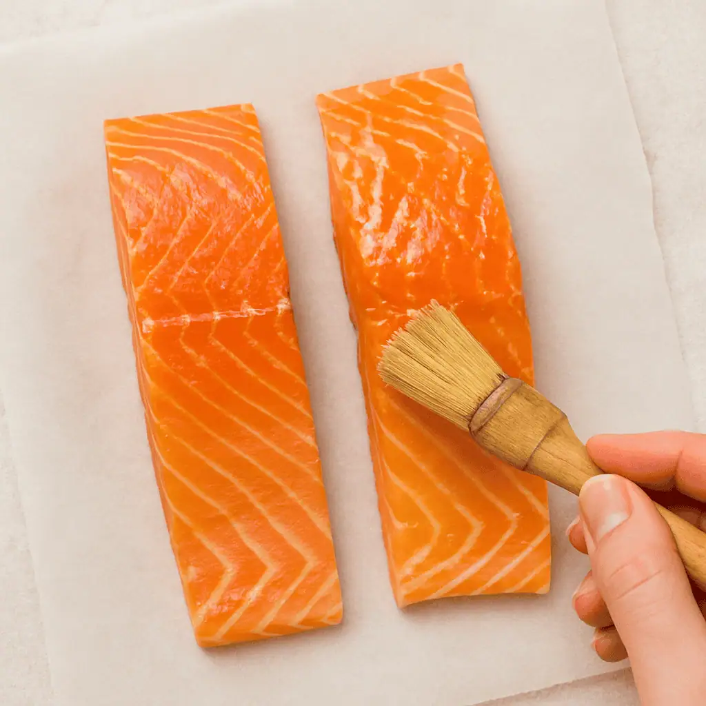 Prep the salmon: Pat the fillets dry and brush the top (flesh side) with olive oil.